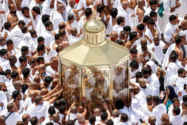 Верующие-мусульмане тянутся за благословением, прикасаясь к макаму Ибрахима в Мекке. - Sputnik Таджикистан