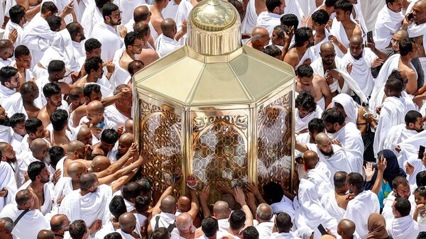 Верующие-мусульмане тянутся за благословением к макаму Ибрахима в Большой мечети в Мекке во время пятничной молитвы в священный месяц Рамадан  - Sputnik Таджикистан