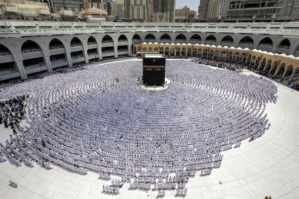 Верующие-мусульмане молятся у Каабы, мусульманской святыни в Заповедной мечети (мечети аль-Харам) в священном городе Мекка во время второй пятничной молитвы в месяц Рамадан. - Sputnik Таджикистан