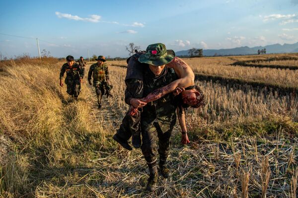 Бойцы сопротивления из Народных сил обороны отступают с телом товарища после столкновения с военными Мьянмы в Мобайе. - Sputnik Таджикистан