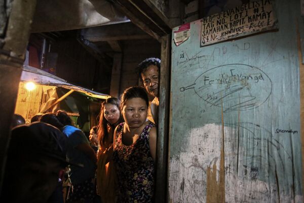 Соседи осматривают место преступления в Мандалуйонге на Филиппинах. - Sputnik Таджикистан