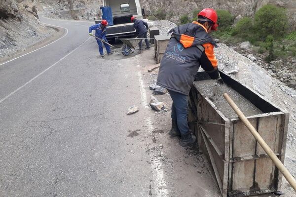 Рабочие устанавливают бетонные отбойники на автотрассе.  - Sputnik Таджикистан