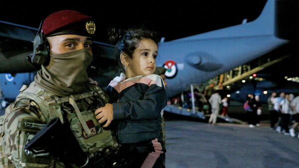 Солдат несет ребенка во время высадки из самолета эвакуированных из Судана граждан на военном аэродроме в Аммане, Иордания - Sputnik Тоҷикистон
