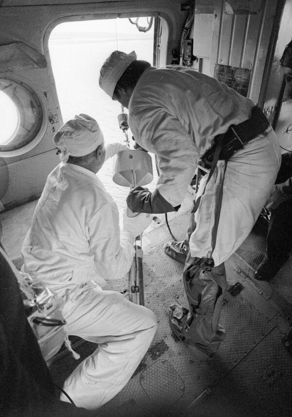 Специалисты берут пробы воды в охладителях реактора Чернобыльской АЭС после катастрофы прямо с борта вертолета. - Sputnik Таджикистан