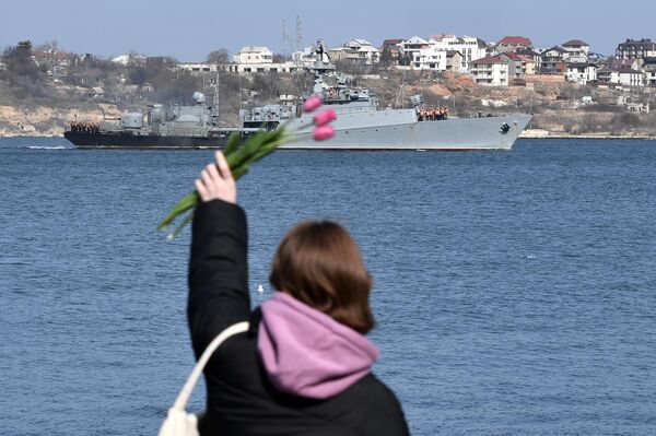 Девушка машет с набережной военному кораблю в Севастополе - Sputnik Таджикистан