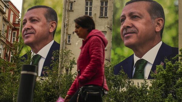 Человек на фоне билборда с президентом Турции Реджепом Тайипом Ердоганом - Sputnik Тоҷикистон