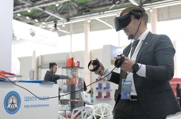 Участник мероприятия изучает стенд в VR-очках. - Sputnik Таджикистан