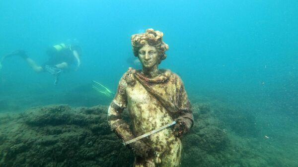 Дайвер показывает туристам копию оригинальной статуи в затопленном древнеримском городе Байи, Италия - Sputnik Таджикистан