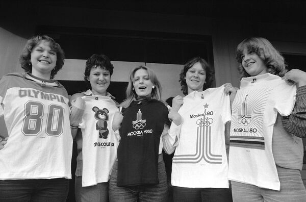 Сотрудницы швейной фабрики, расположенной под Штутгартом,  держат в руках пять разных футболок с эмблемами Московской Олимпиады 1980 года. - Sputnik Таджикистан