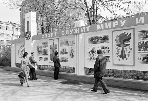 Москвичи осматривают новый олимпийский рекламный щит с надписью &quot;Спорт служит миру&quot;. - Sputnik Таджикистан