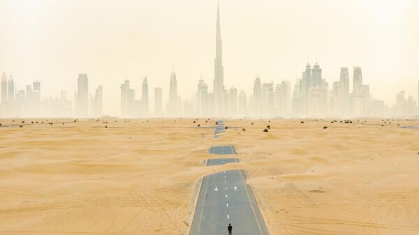 Пустынная дорога, покрытая песчаными дюнами в Дубае, ОАЭ - Sputnik Тоҷикистон