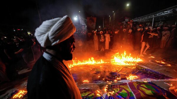 Сторонники лидера мусульман-шиитов Муктады Садра сжигают радужные флаги во время демонстрации в Садр-Сити в ответ на сожжение Корана в Швеции, Багдаде, Ирак - Sputnik Таджикистан