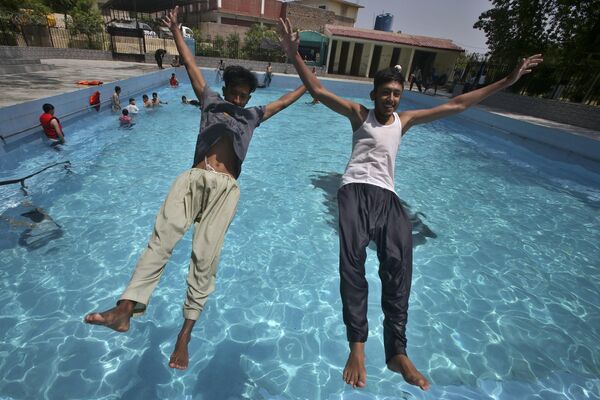 В Пакистане молодежь прыгает в бассейн, чтобы охладиться, когда температура достигла 39. - Sputnik Таджикистан