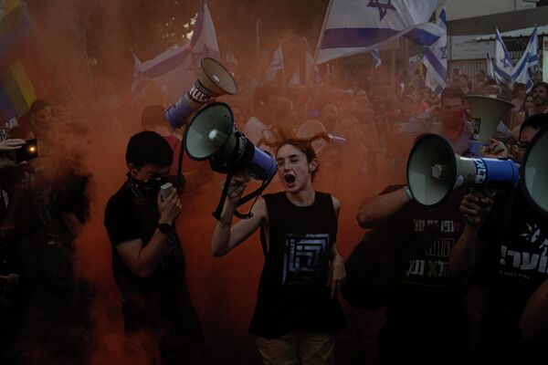 Демонстранты выкрикивают лозунги во время акции протеста против планов правительства премьер-министра Биньямина Нетаньяху по пересмотру судебной системы в Тель-Авиве. - Sputnik Таджикистан