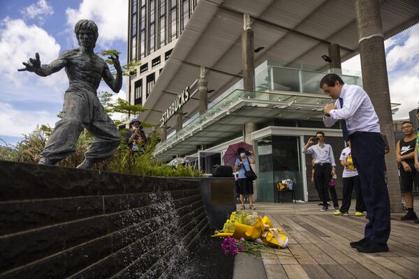 Поклонники собираются перед статуей мастера боевых искусств Брюса Ли, чтобы отметить 50-ю годовщину его смерти в Гонконге 20 июля 2023 года.  - Sputnik Таджикистан