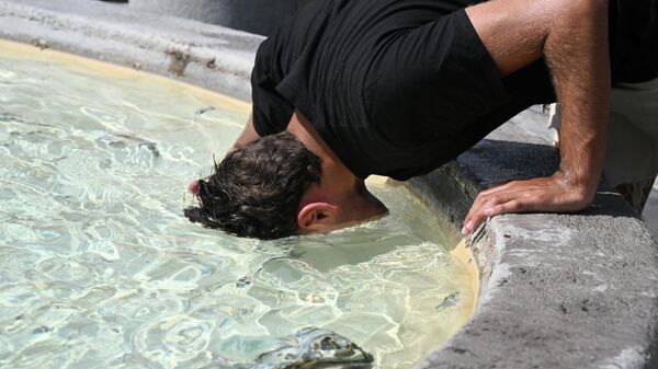 Мужчина опускает голову в воду, чтобы охладиться у фонтана на площади Пьяцца дель Пополо в Риме, Италия - Sputnik Таджикистан