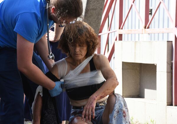 Медицинский сотрудник оказывает помощь женщине, раненной в результате обстрела Донецка со стороны ВСУ.  - Sputnik Таджикистан