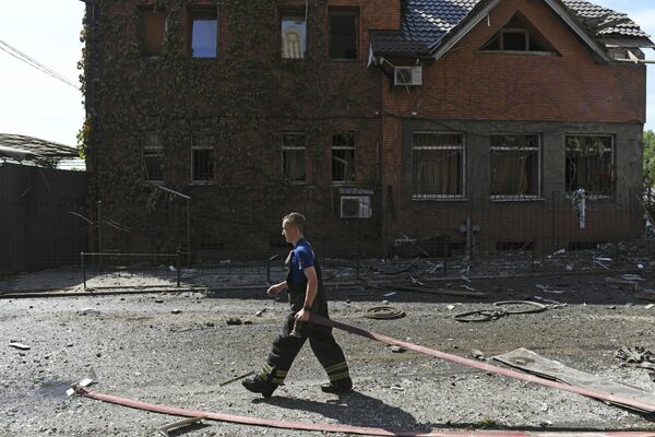 Пожарный у дома, разрушенного в результате обстрела Донецка со стороны ВСУ.  - Sputnik Таджикистан