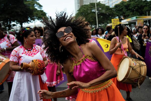 Женщина танцует во время Марша чернокожих женщин против расизма, насилия и угнетения на пляже Копакабана в Рио-де-Жанейро, Бразилия. - Sputnik Таджикистан