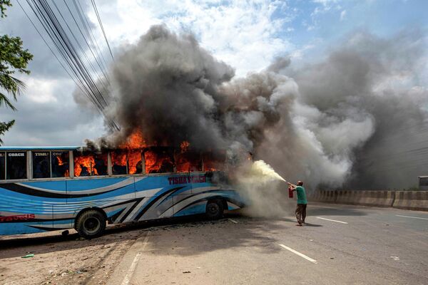 Активисты Националистической партии Бангладеш (BNP) подожгли автобус, перекрывая шоссе в Дакке 29 июля 2023 года. - Sputnik Таджикистан