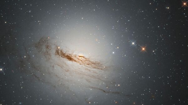 Линзовидная галактика NGC 1947, имеющая форму между спиралью и эллиптической, потерявшая почти весь газ и пыль из своих спиральных рукавов, которые раньше вращались вокруг ее центра - Sputnik Таджикистан