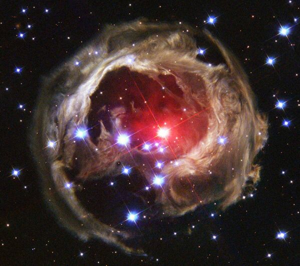 Движущееся наружу световое эхо яркой вспышки звезды V838 Mon. Она находится на расстоянии около 20 тыс. световых лет от созвездия Единорога, а диаметр светового эха выше составляет около 6 световых лет. - Sputnik Таджикистан
