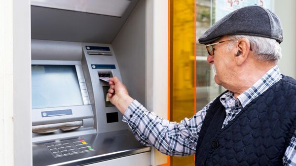Пожилой мужчина у банкомата - Sputnik Таджикистан