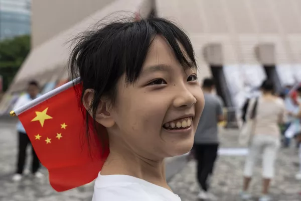Девушка с китайским флагом в волосах в честь торжества. - Sputnik Таджикистан