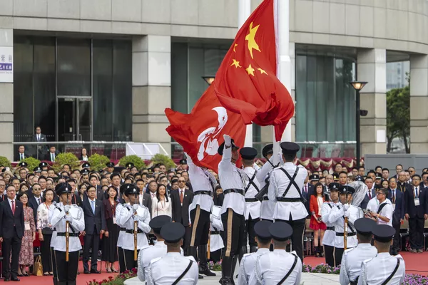 Участники наблюдают за церемонией поднятия флагов Гонконга и Китая в честь празднования 74-го Национального дня Китайской Народной Республики. - Sputnik Таджикистан