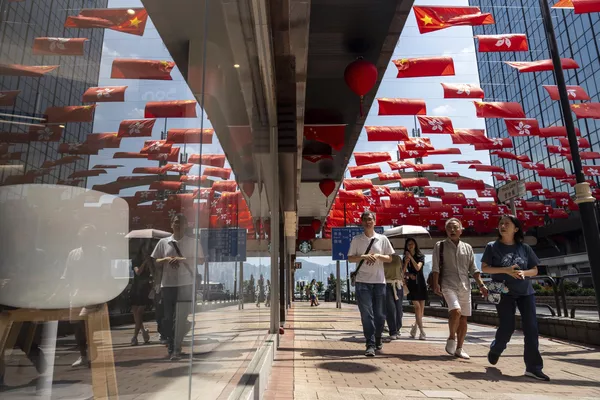 Пешеходы проходят мимо флагов Китая и Гонконга, когда город отмечает национальный день Китая. - Sputnik Таджикистан