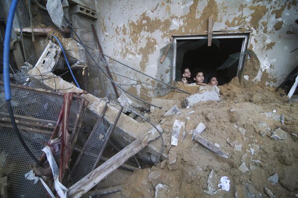 Палестинские дети смотрят на разрушенный дом в Рафахе. - Sputnik Таджикистан