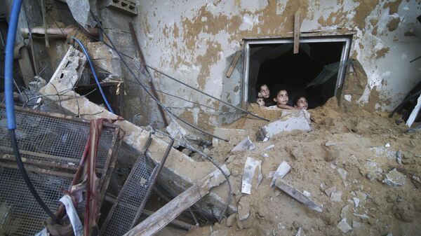 Палестинские дети выглядывают из-под руин разрушенного здания в результате израильских авиаударов в Рафахе, сектор Газа - Sputnik Тоҷикистон