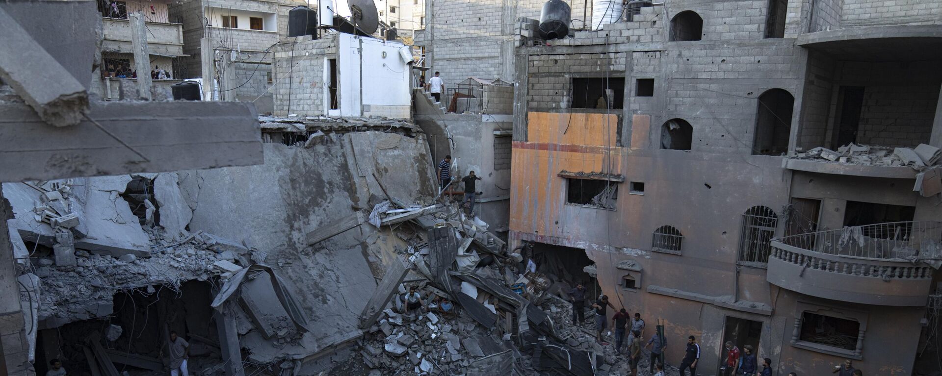 Палестинцы ищут выживших в здании, разрушенном в результате израильской бомбардировки в Хан-Юнисе, сектор Газа - Sputnik Тоҷикистон, 1920, 24.11.2023