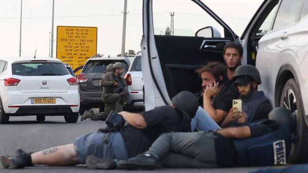 Журналисты прячутся за автомобилями, пока израильские солдаты занимают позиции во время столкновений с палестинскими боевиками возле кибуца Гевим на границе с Газой - Sputnik Таджикистан