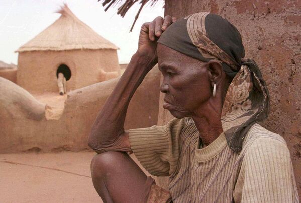 Суклаар, женщина, обвиненная в колдовстве, сидит на земле в деревне Гамбага, Гана. Гамбага - одна из &quot;деревень ведьм&quot; в Гане, где живут женщины, обвиненные в колдовстве, после того, как их прогнали из своих домов. - Sputnik Таджикистан