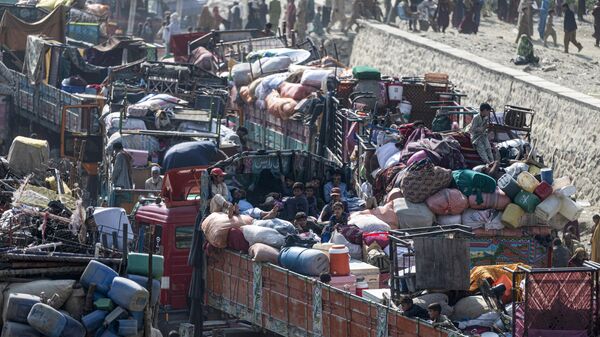 Афганские беженцы прибывают на грузовиках из Пакистана на афгано-пакистанскую границу Торхам в провинции Нангархар - Sputnik Тоҷикистон