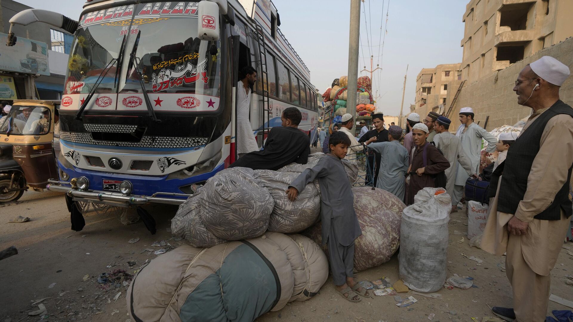 Афганские семьи ждут посадки в автобусы, чтобы отправиться на родину, в Карачи, Пакистан - Sputnik Тоҷикистон, 1920, 09.11.2023