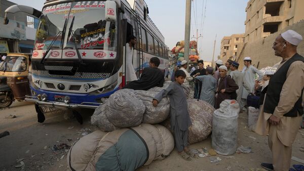 Афганские семьи ждут посадки в автобусы, чтобы отправиться на родину, в Карачи, Пакистан - Sputnik Таджикистан