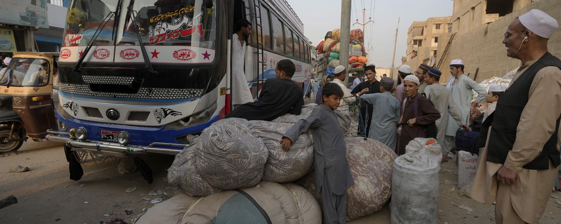 Афганские семьи ждут посадки в автобусы, чтобы отправиться на родину, в Карачи, Пакистан - Sputnik Тоҷикистон, 1920, 09.11.2023