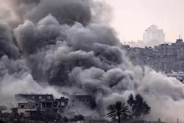 Столб дыма, вырывающийся во время израильской бомбардировки палестинского анклава на фоне продолжающихся боев. По данным Министерства здравоохранения, управляемого ХАМАСом, более 10 тыс. человек погибли в результате израильских бомбардировок сектора Газа с тех пор. - Sputnik Таджикистан