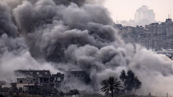 Столб дыма, поднимающийся во время израильской бомбардировки палестинского анклава на фоне продолжающихся боев - Sputnik Тоҷикистон