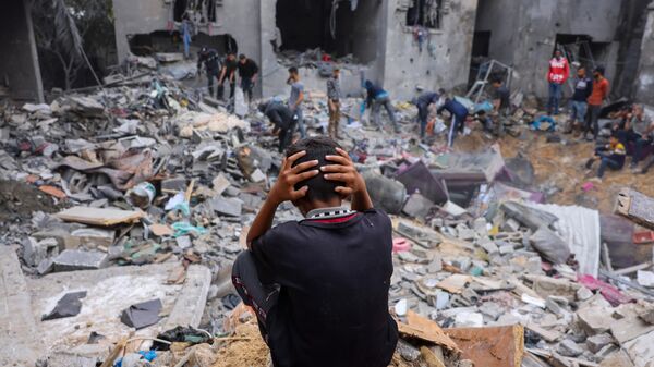 Ребенок среди обломков поврежденного здания после ударов по Рафаху на юге сектора Газа - Sputnik Тоҷикистон
