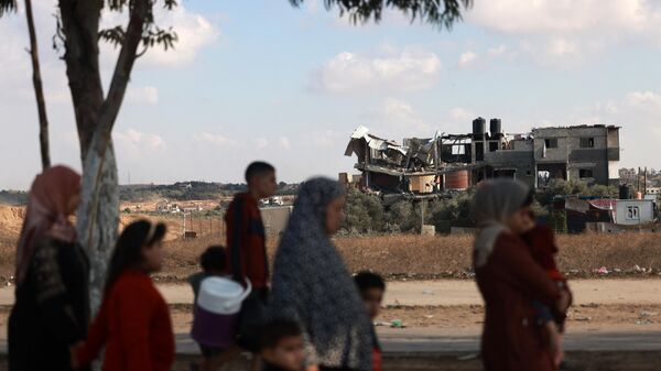 Палестинцы идут по дороге, покидая город Газа в направлении южных районов - Sputnik Тоҷикистон