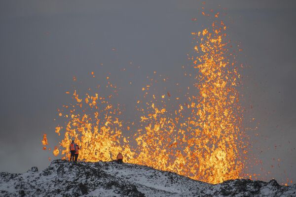Ученые из Исландского университета проводят измерения и берут образцы, стоя на хребте действующего вулкана. - Sputnik Таджикистан