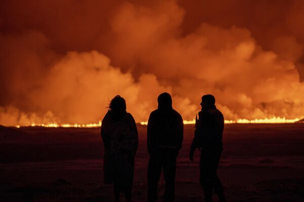 Люди смотрят, как ночное небо освещается всполохами огня с вулкана. - Sputnik Таджикистан