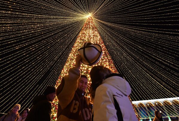 Люди гуляют на центральной площади Ала-Тоо, украшенной в честь предстоящего Нового года, в Бишкеке. Новый год, который был самым большим неформальным праздником года в бывшем Советском Союзе, также очень популярен  преимущественно в мусульманской стране Кыргызстане. - Sputnik Таджикистан