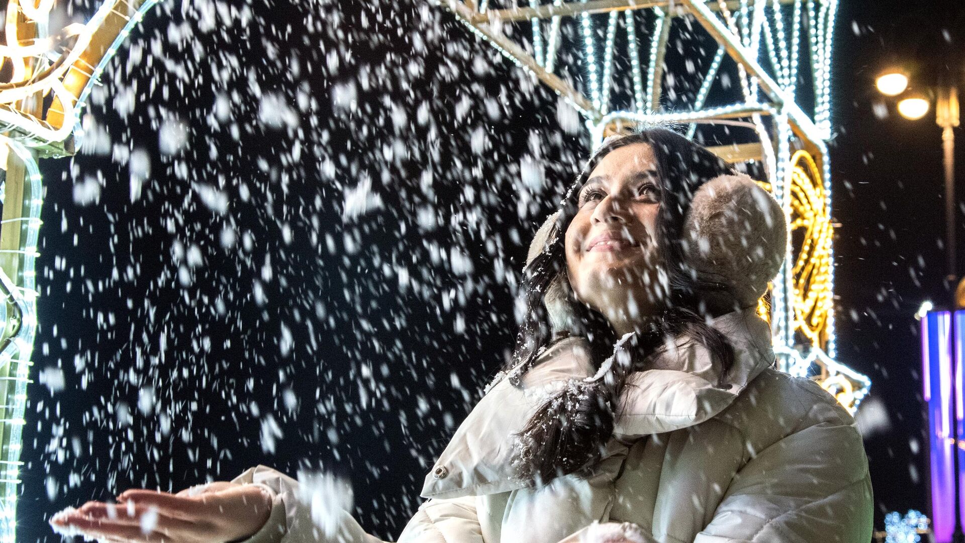 Девушка ловит снежинки у новогодней елки в Бишкеке. - Sputnik Таджикистан, 1920, 31.12.2023