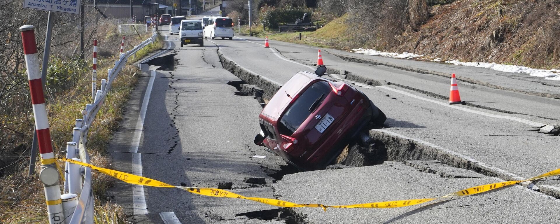 Автомобиль застрял на частично обрушившейся дороге, вызванной мощным землетрясением, недалеко от города Анамидзу, префектура Исикава - Sputnik Таджикистан, 1920, 03.01.2024
