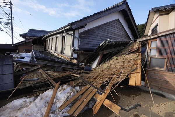 Двухэтажный дом с обрушившимся первым этажом в результате сильных толчков в Японии. - Sputnik Таджикистан