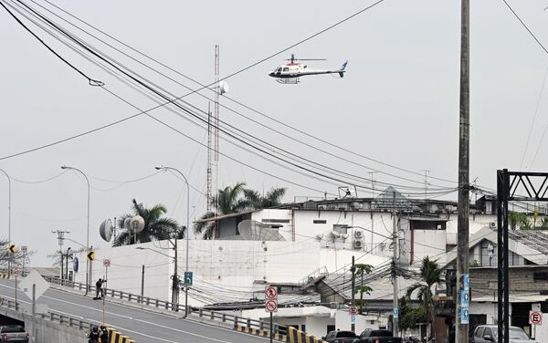 Вертолет эквадорской полиции пролетает над помещением эквадорского телеканала TC Television после того, как неизвестные вооруженные люди ворвались в государственную телестудию в прямом эфире. - Sputnik Таджикистан